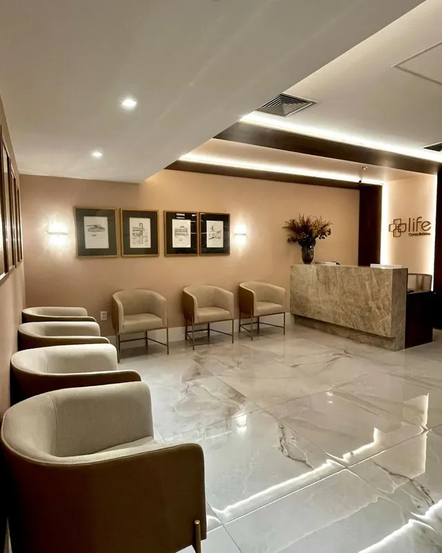 Ambiente de espera com poltronas e quadros